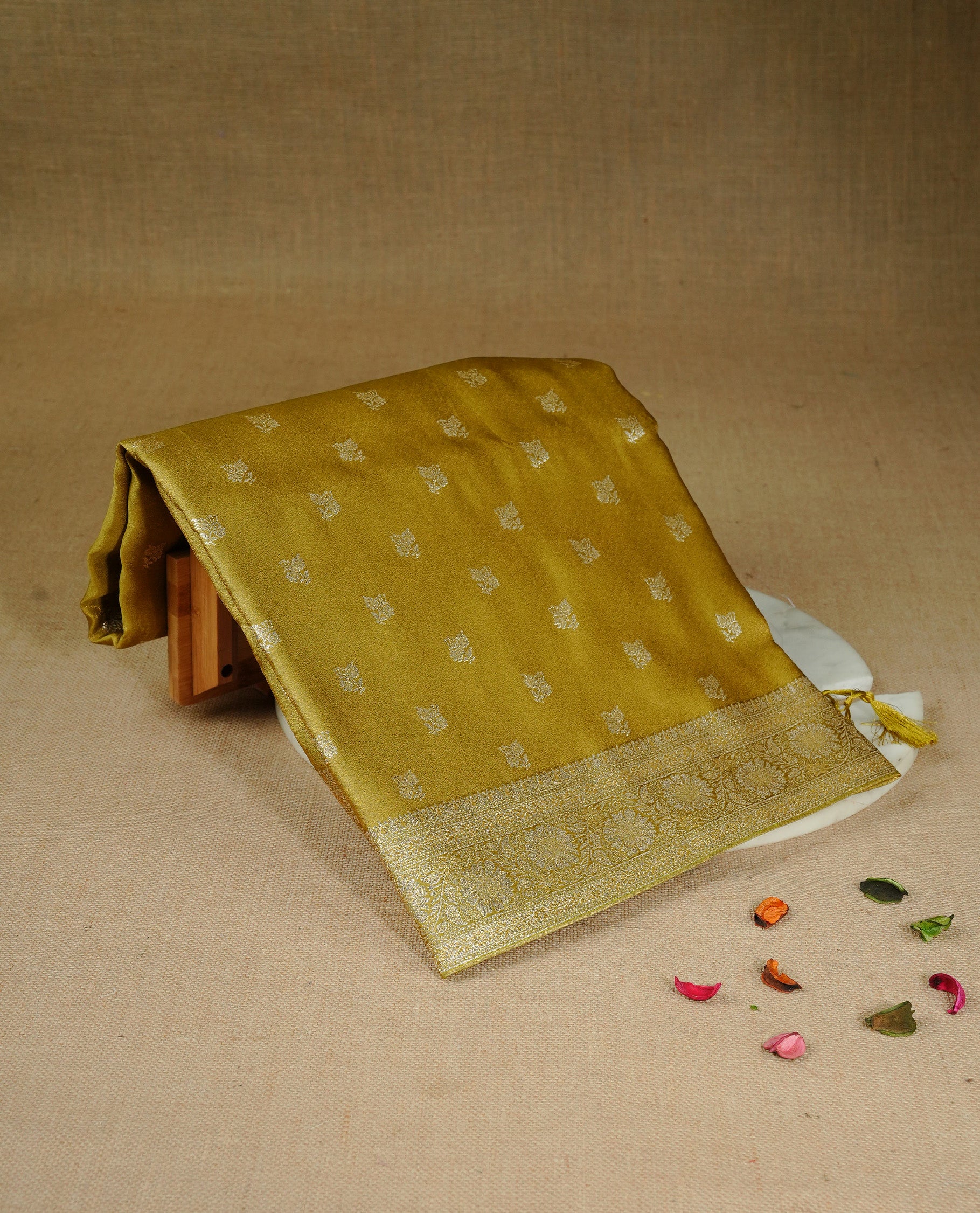 Olive colour Mulberry silk saree featuring gold zari motifs on body, complemented by contrast self colour with gold zari border, comes with matching blouse piece.