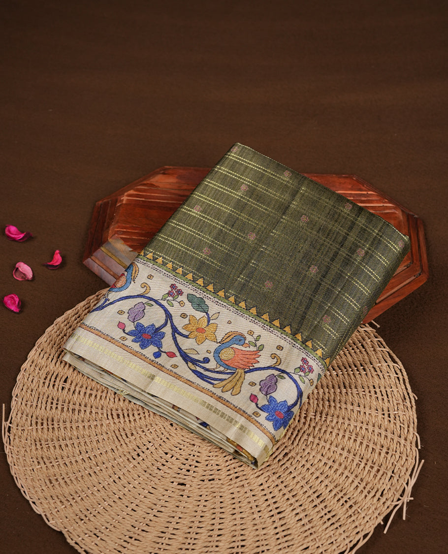 Olive green colour semi tusser silk saree featuring gold zari check pattern with floral butti motifs, with contrast floral kodi & bird pattern and paired with matching blouse.