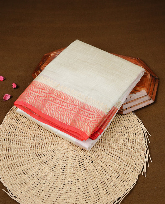 White cream colour Semi Tussar silk saree featuring an elegant plain body, accentuated by a contrast red border adorned with intricate gold zigzag zari work, paired with a matching blouse piece.