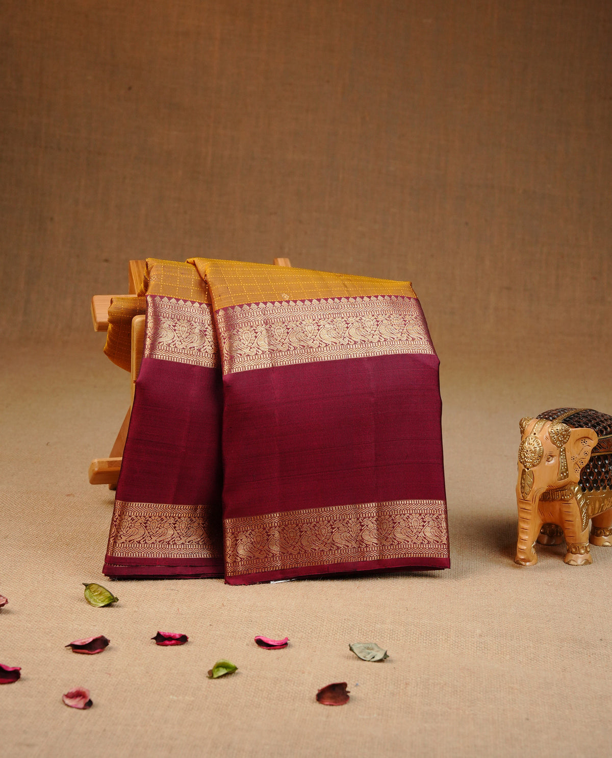 Mustard olive colour Traditional kancheepuram silk saree featuring Gold zari check on body, complemented by Contrast maroon colour with Gold Zari border, comes with matching blouse piece.