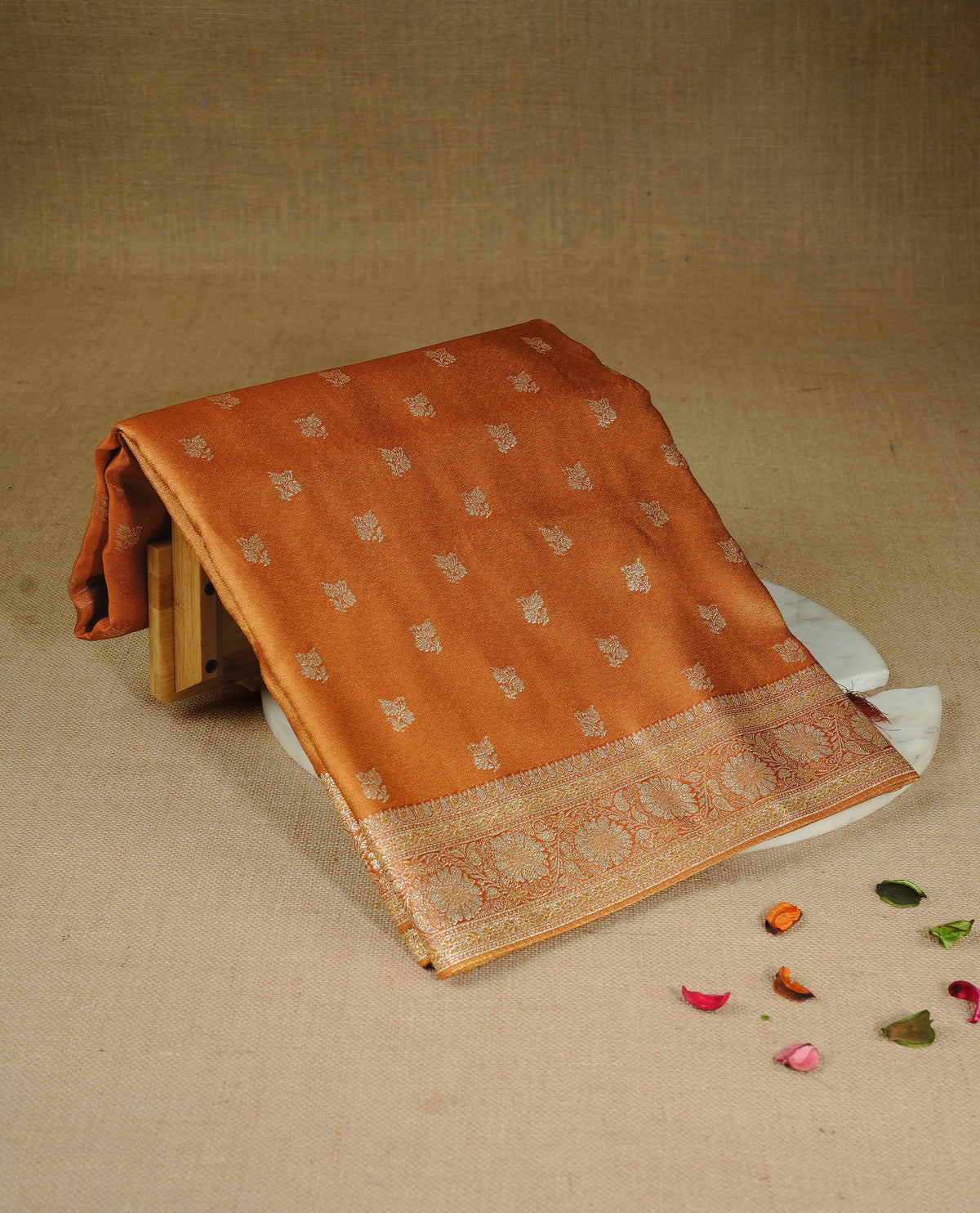 Orange colour Mulberry silk saree featuring gold zari motifs on body, complemented by contrast self colour with gold zari border, comes with matching blouse piece.
