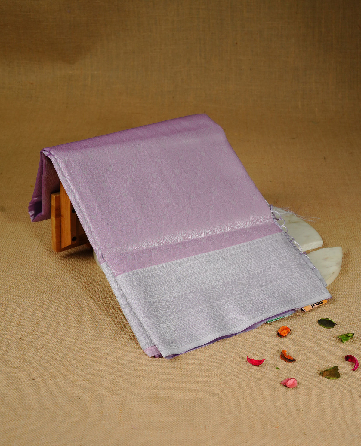 Pink colour semi silk saree featuring Silver zari Design pattern on body, complemented by contrast Lavender colour with silver zari border, comes with matching blouse piece.