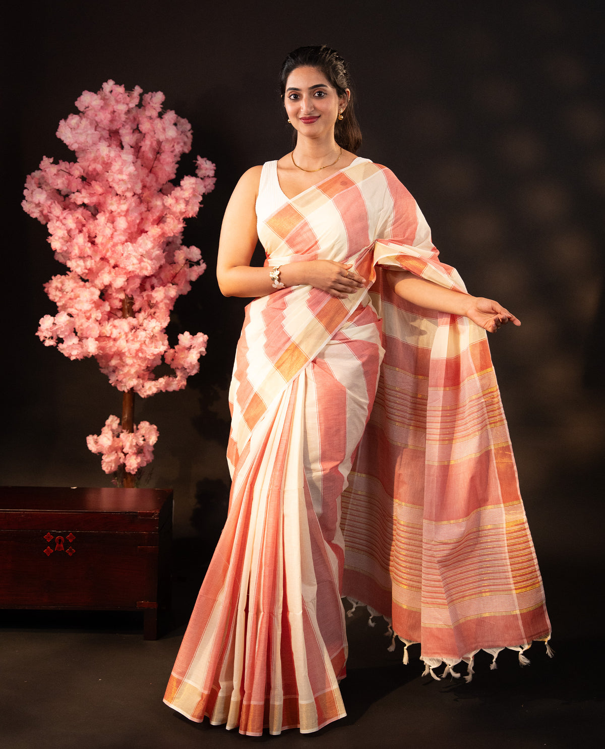 Red & Beige dual colour Poly cotton saree featuring Stripped design body, complemented by kasavu border and pallu Finished with elegant tassels, comes with matching blouse piece.