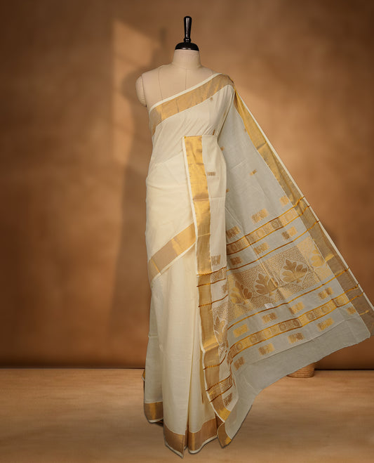 Elegant Off white colour cotton Kerala saree with gold zari buttas, broad kasavu border, and richly woven traditional pallu, paired with a matching blouse