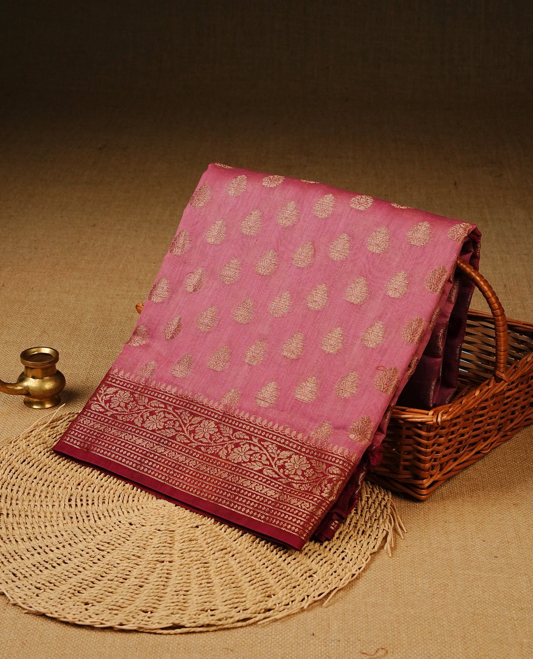 Onion Pink colour Tussar Silk saree featuring antique zari butta motifs on the body, complemented by a contrasting maroon floral zari border and pallu, paired with a matching blouse piece.
