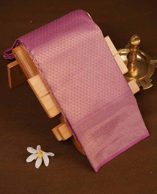 Lavender colour semi soft silk saree featuring gold zari motifs on across body, self colour border with traditional gold zari pattern, pallu and paired with matching blouse.