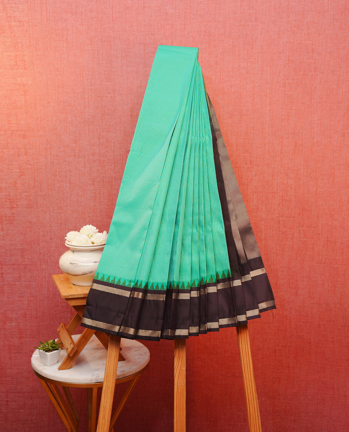 Aqua blue colour soft silk saree featuring gold zari stripes on body, contrast dark chocolate colour gold zari simple border, grand pallu comes with matching blouse piece.