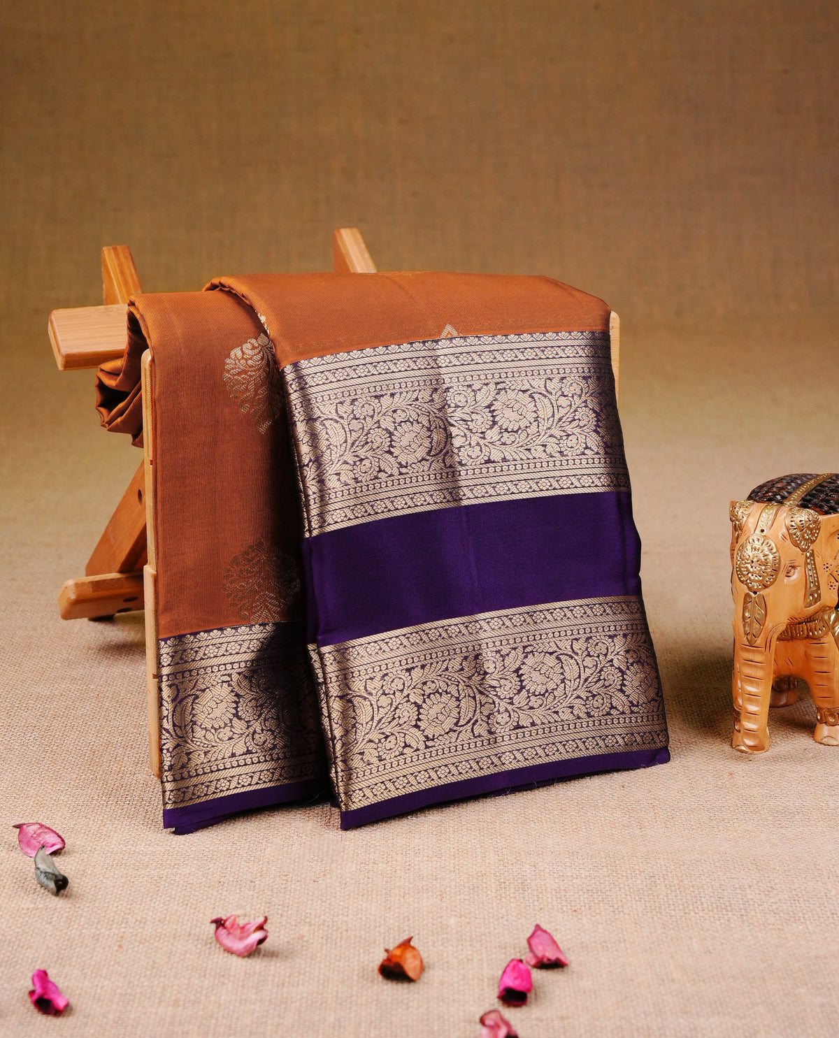 Rust Orange colour Traditional Kancheepuram Silk Saree with Elegant Gold Zari Buttas on the Body, Enhanced with a Contrast Purple Colour with Gold Zari Border and Rich Pallu, Paired with a Matching Blouse Piece.