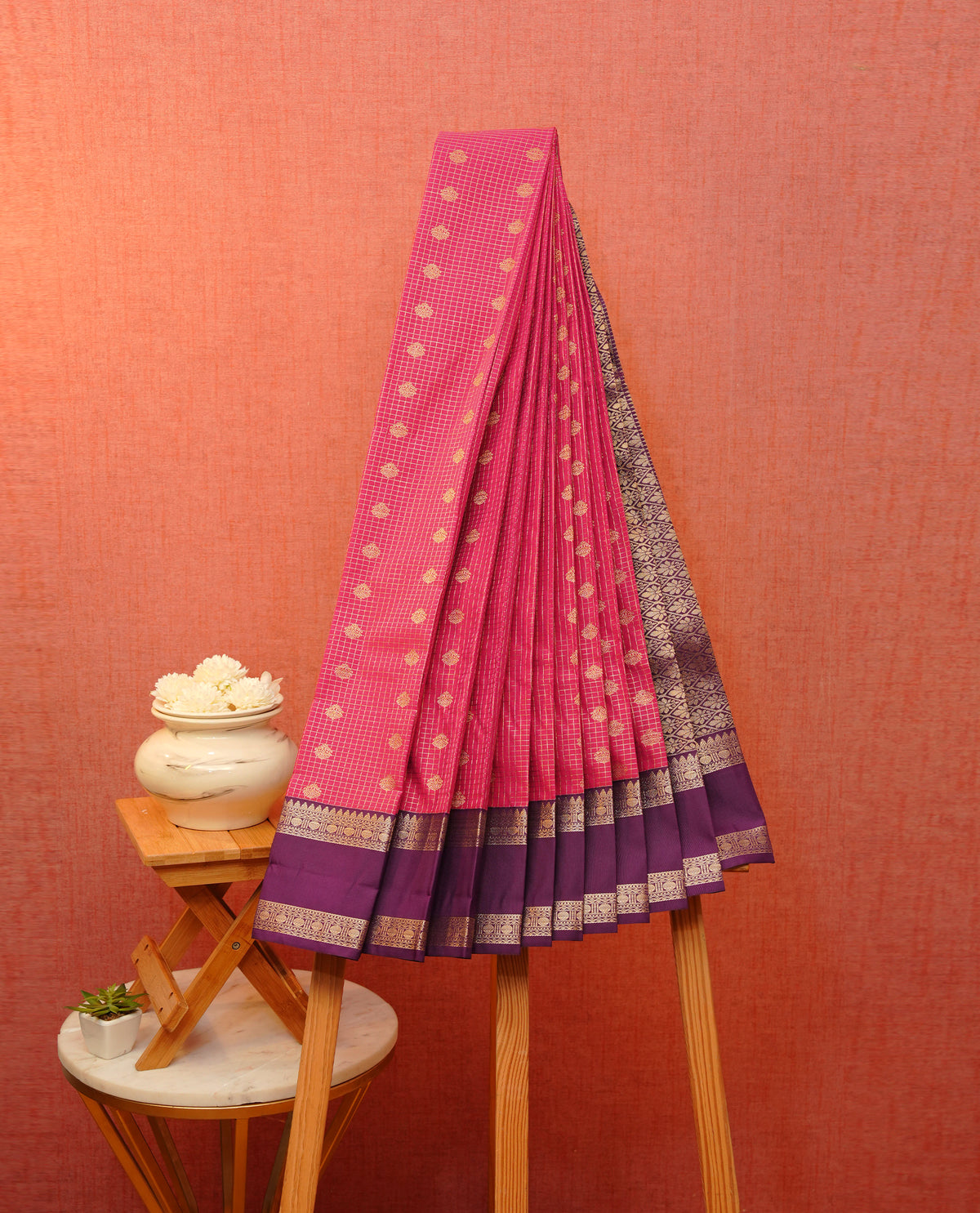 Dark magenta colour soft silk saree featuring gold zari checks with floral mottifs on body, contrast purple colour gold zari traditional border, grand pallu comes with matching blouse piece.