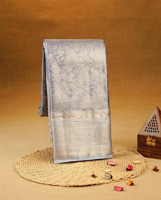 Lavender Colour Tissue Silk Saree featuring an elegant all-over floral Kodi zari woven body, a richly woven Gold zari pallu, complemented by a matching Gold zari border and paired with a self-coloured blouse piece.