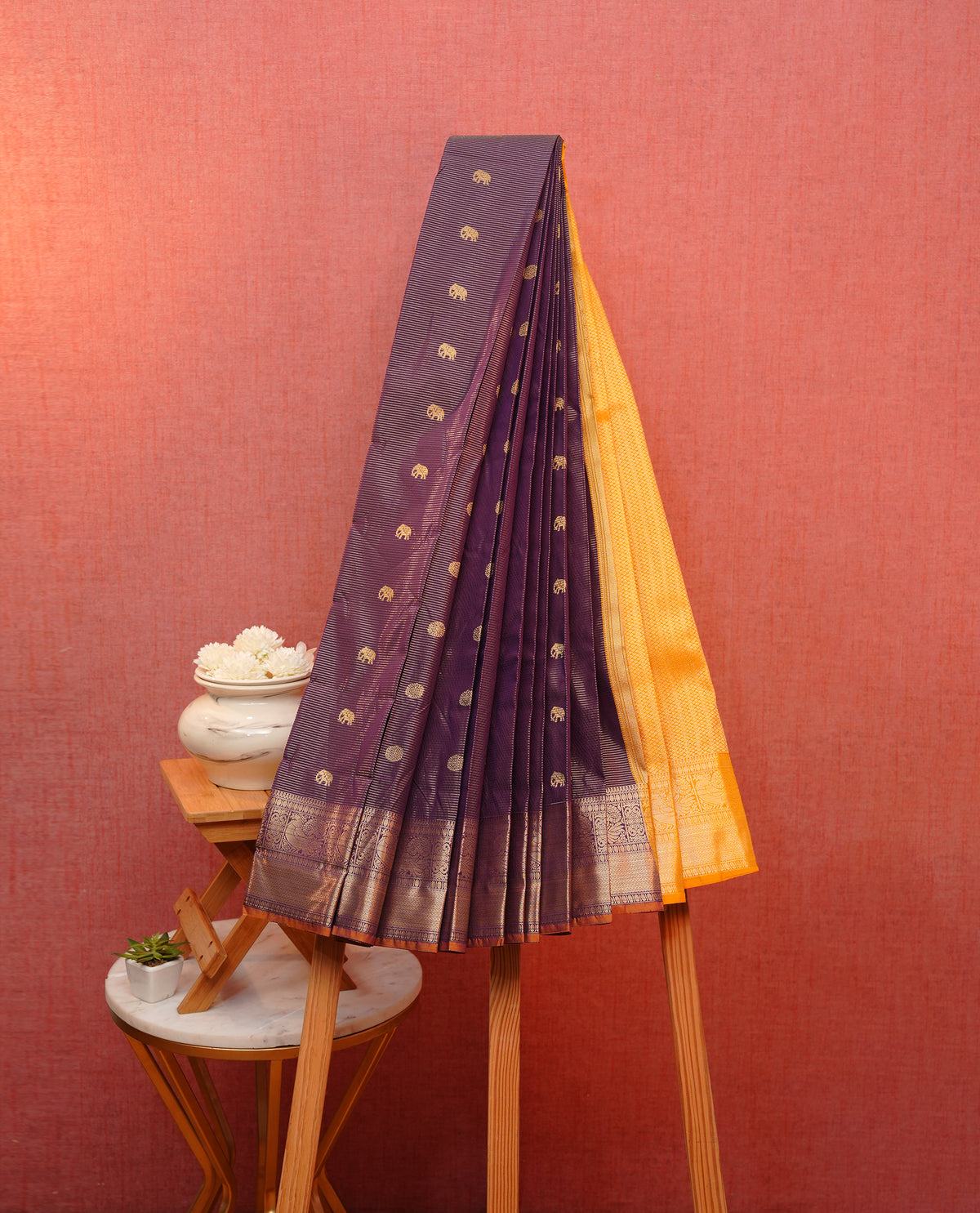 Purple colour soft silk saree featuring gold zari lines with elephant motifs on body, contrast Mustard yellow colour gold zari peacock motifs on border, grand pallu comes with matching blouse piece.