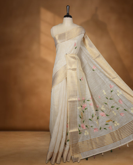 Beige colour Banarasi linen silk saree featuring hand brushed colour with Floral  & birds printed pattern on body, gold zari woven geometric design border with self colour pallu and comes with a matching blouse