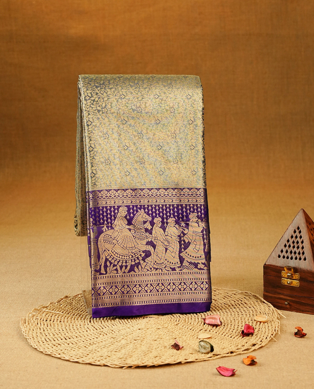 Blue colour Semi Tissue Silk Saree featuring gold zari floral kodi Works on the body, complemented by an intricately woven gold zari pallu, a rich Deep Purple border with traditional gold zari work and paired with a matching plain blouse piece.