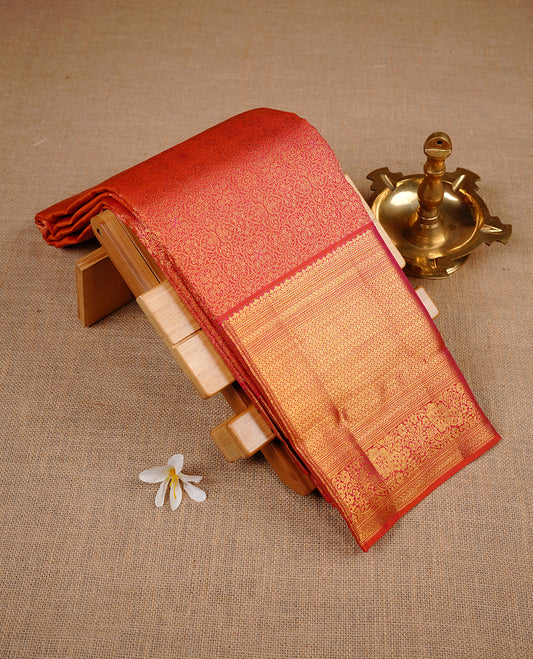 Orange colour kancheepuram silk saree featuring gold zari pattern across body, complemented by selfcolour border traditional zari border, paired with matching blouse piece.
