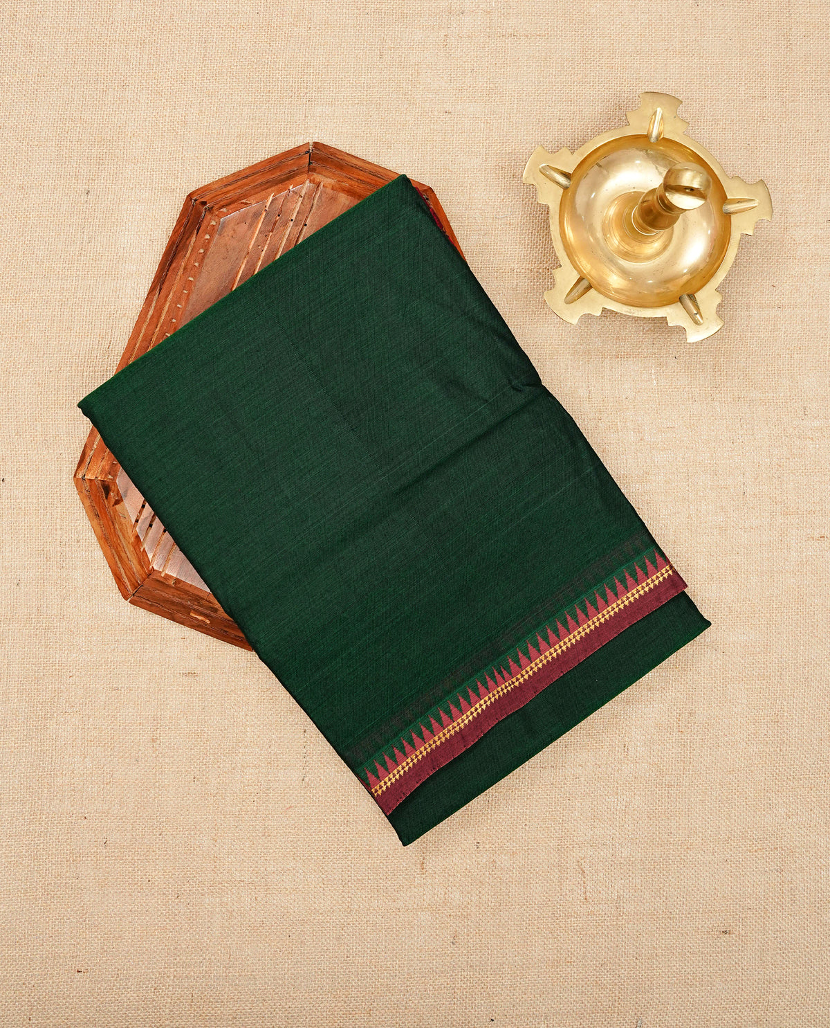 Dark Green colour Narayanapattu cotton saree with a plain body, complemented by a Maroon colour with gold zari and red colour temple designed border & contrast pallu, paired with a matching blouse piece.