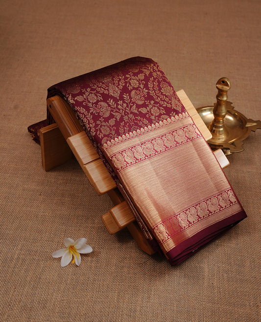 Maroon colour kancheepuram silk saree featuring gold zari floral kodi pattern on body, complemented by self colour with traditional border, paired with matching blouse piece.