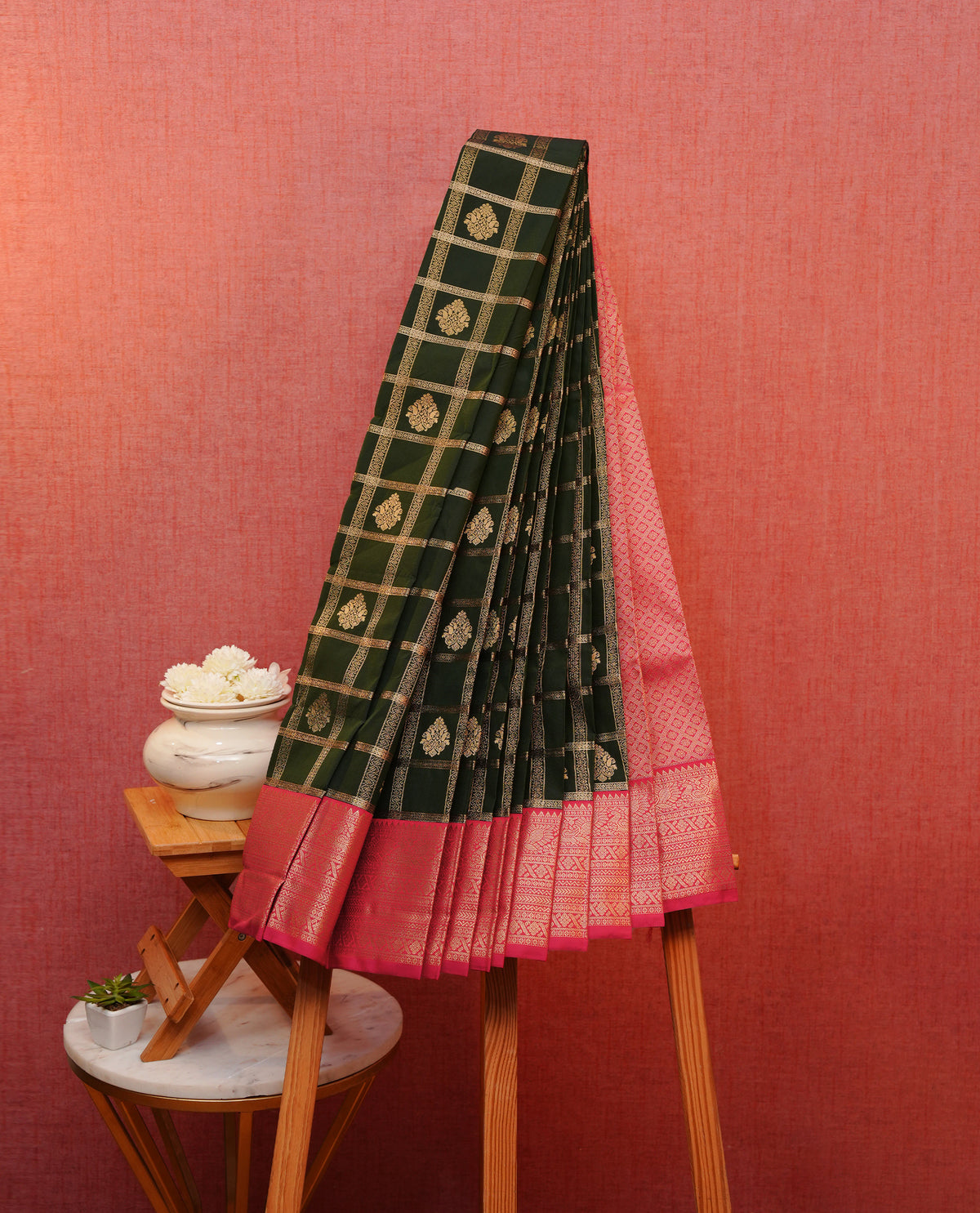 Dark green colour soft silk saree featuring gold zari checks with floral motifs on body, contrast rani pink colour gold zari traditional border, grand pallu comes with matching blouse piece.