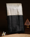 Silver colour semi tissue silk saree featuring gold zari check pattern on body, contrast Black colour with selfcolour traditional border, paired with matching blouse piece.