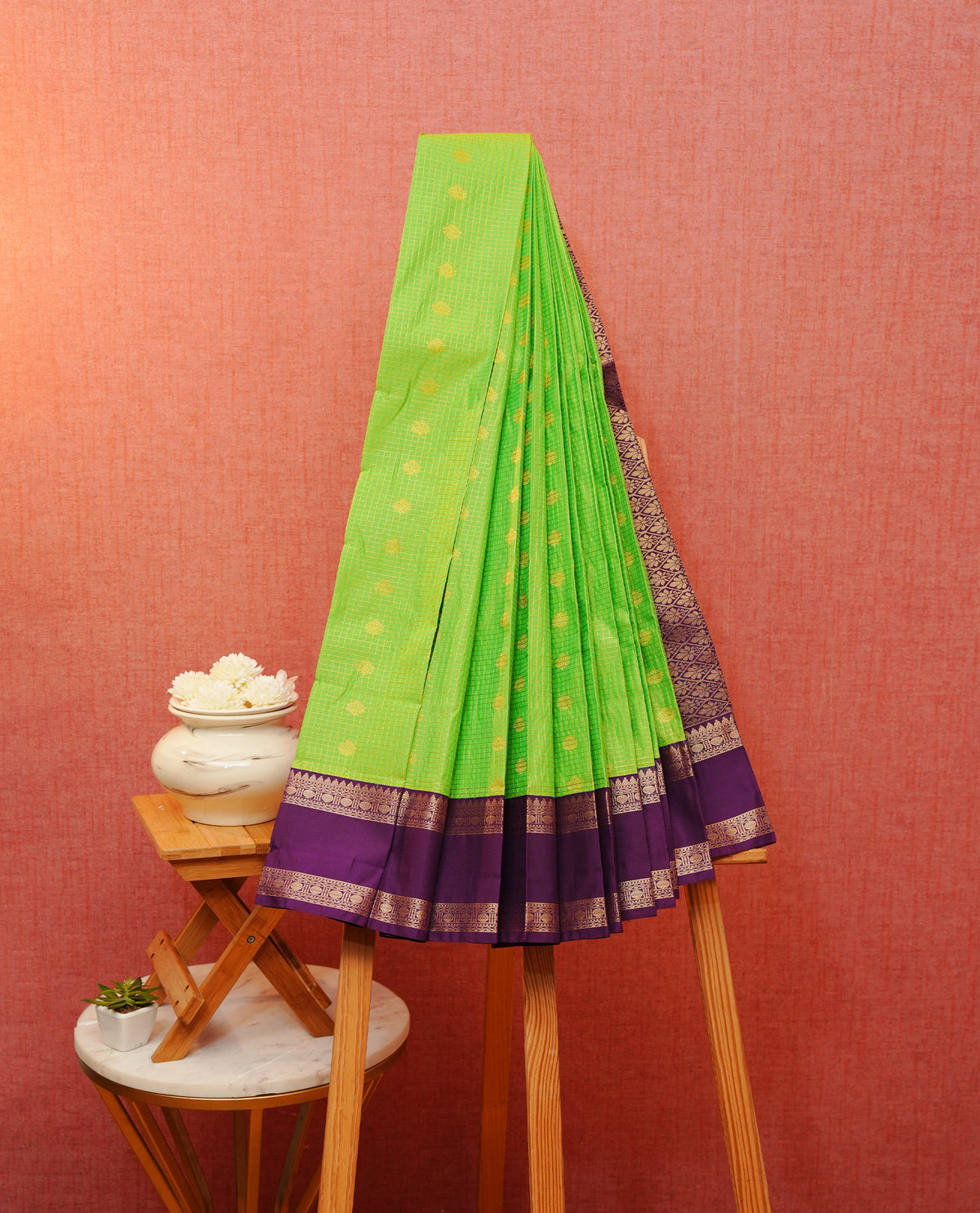 Light green colour soft silk saree featuring gold zari checks & motifs on body, contrast purple colour traditional border, grand pallu comes with matching blouse piece.