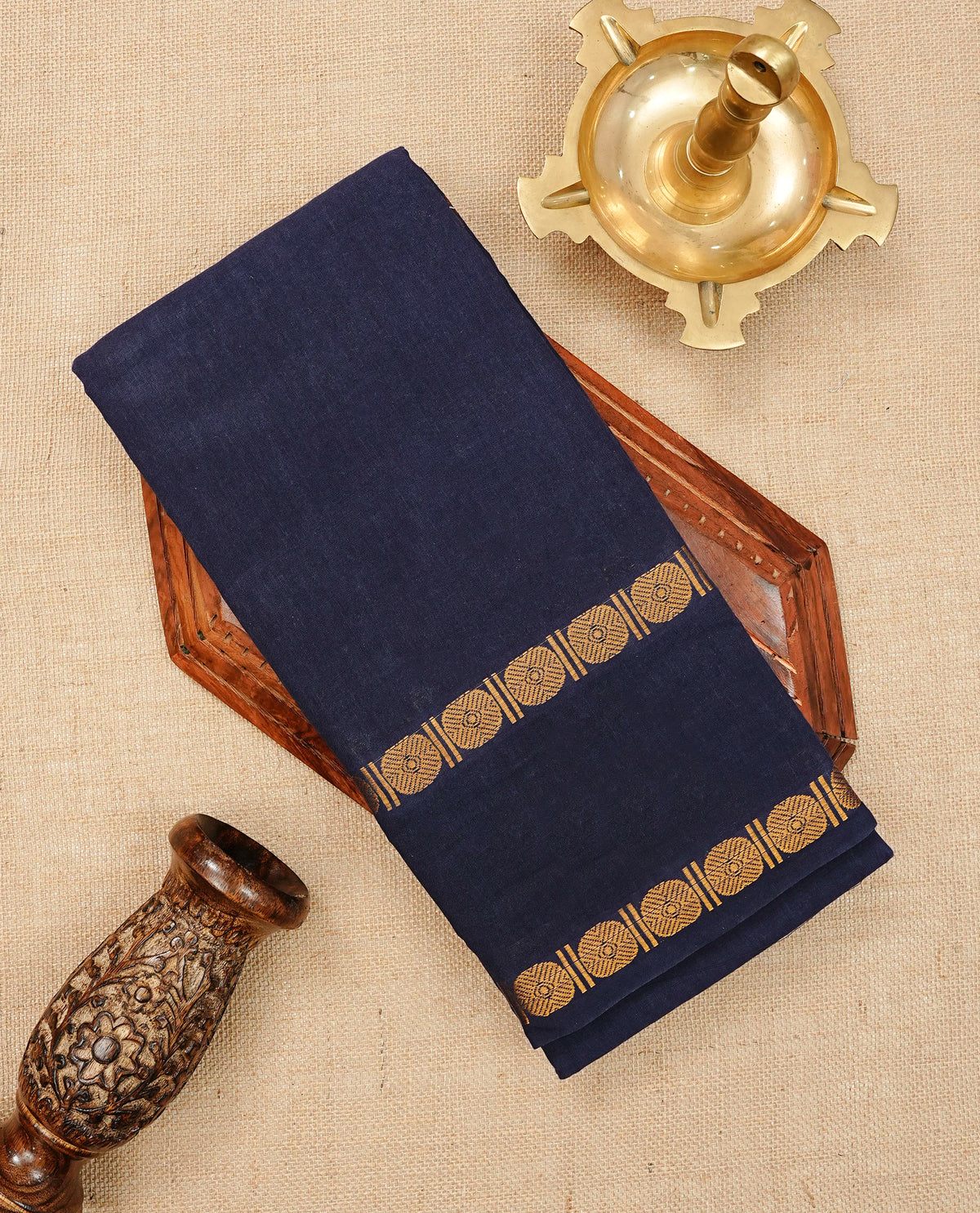 Navy Blue Colour  Sungudi Cotton Saree with gold zari motifs on the body, a matching gold zari border, and a plain pallu. Paired with a contrast Red colour  blouse piece  featuring a gold zari peacock border.