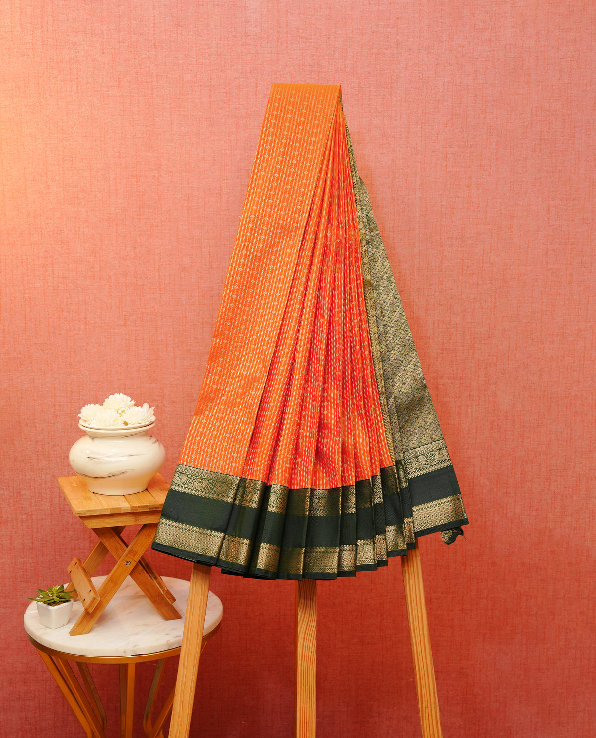 Rust orange colour soft silk saree featuring gold zari stripes with buttas on body, contrast dark green colour gold zari peacock traditional border, grand pallu comes with matching blouse piece.