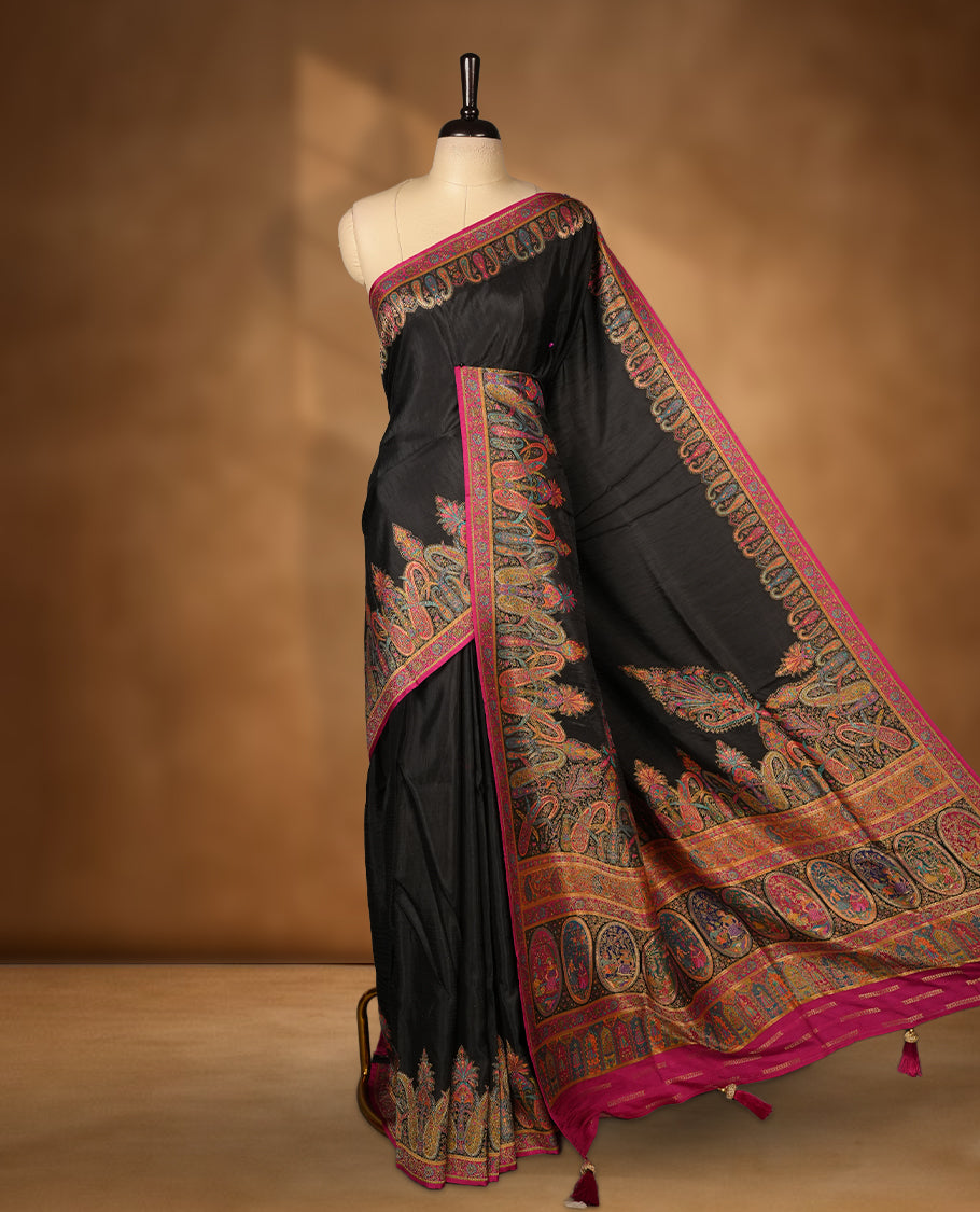 Black colour Pashmina silk saree densely woven with intricate multicolour floral and architectural motifs across the body, framed by an opulent arabesque border and grand storytelling pallu, paired with a matching black woven border blouse piece