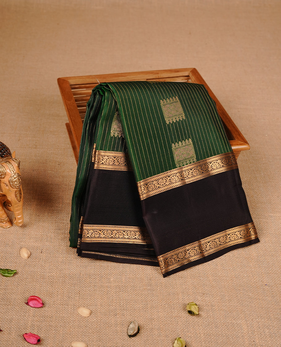 Green colour traditional kancheepuram silk saree featuring gold zari stripes & motifs on body, complemeneted by contrast chocolate colour with traditional border, paired with matching blouse piece.