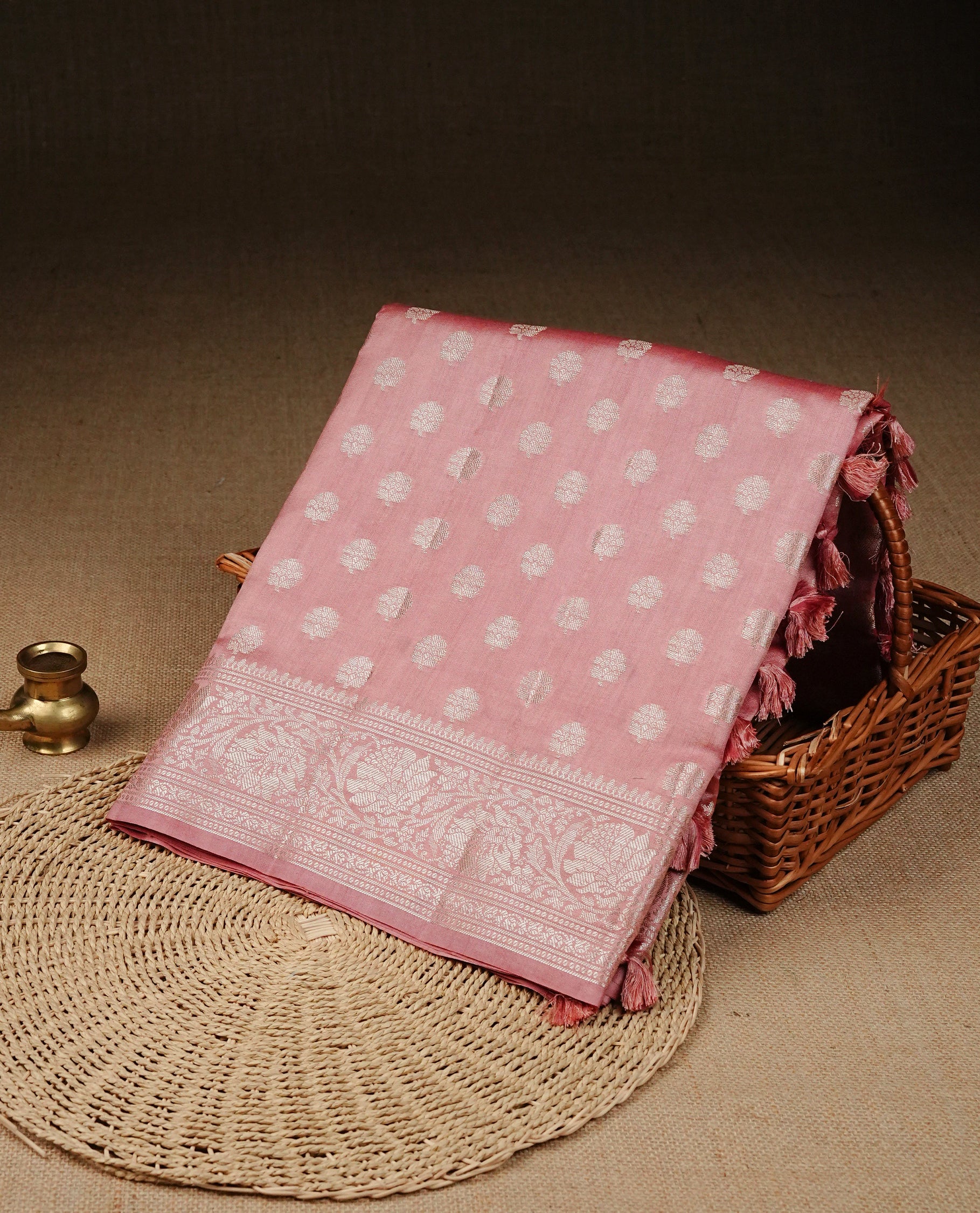 Peach Pink Colour Tussar Silk Saree with silver zari buttas on the body, an elegant silver zari border and intricately designed pallu, paired with a matching blouse piece.