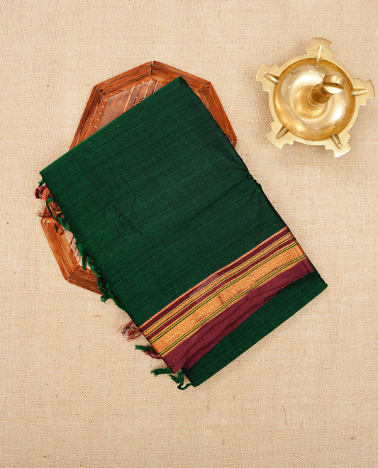 Bottle green colour Narayanapattu cotton saree with a plain body, complemented by a Maroon colour with elegant gold zari detailing border & contrast striped pallu, paired with a matching blouse piece.