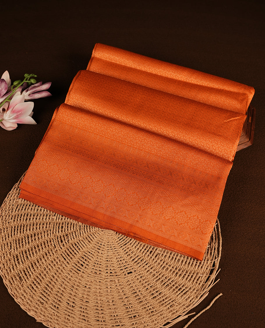 Orange colour softie silk saree featuring ovel shape stripes across body, complemented by self colour with traditional border, paired with matching blouse piece.