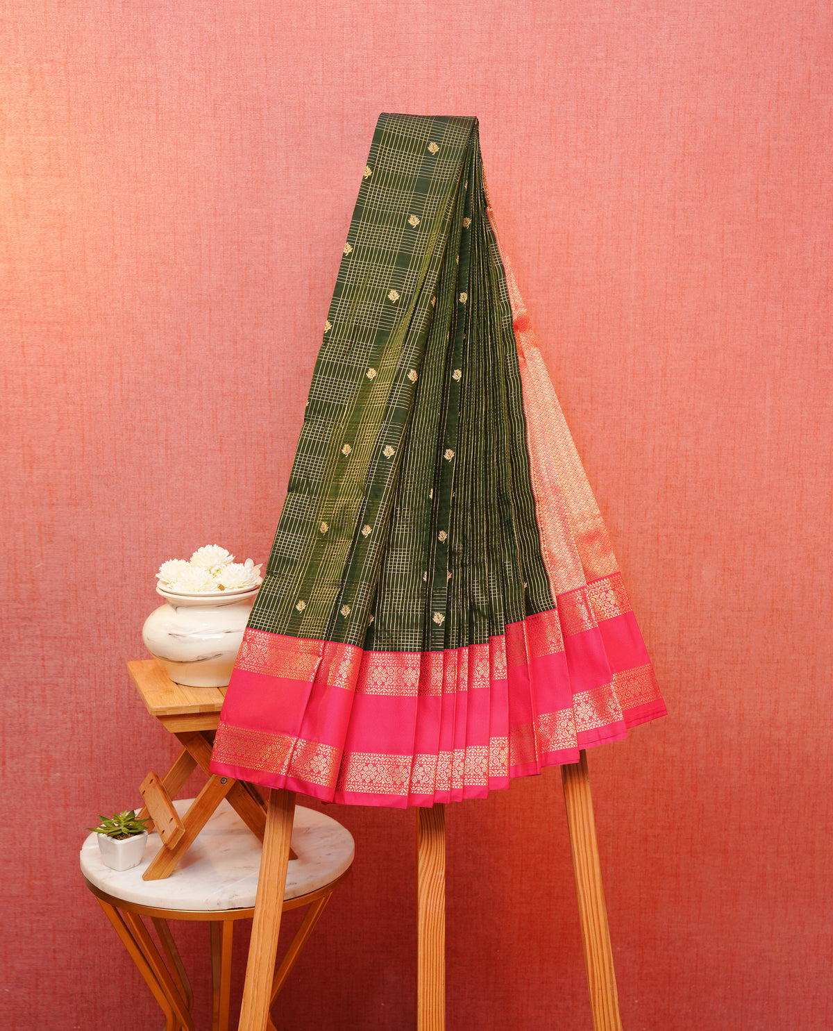 Dark green colour soft silk saree featuring gold zari checks with floral motifs on body, contrast Rani pink colour gold zari traditonal border, grand pallu comes with matching blouse piece.