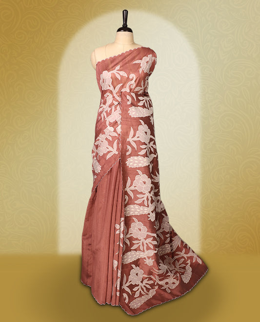 Mauve colour semi tussar saree adorned with elegant white applique work in leaf and floral designs across the body and border, paired with a matching blouse.