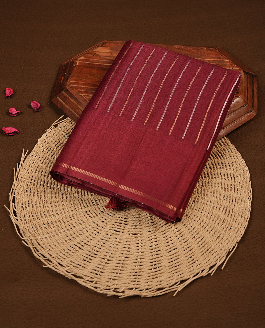 Brown colour semi tussar saree highlights gold and silver zari stripes across body,  border, pallu and paired with matching blouse piece.