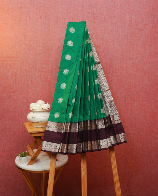 Green colour silk saree featuring gold zari motifs on body, contrast brown with gold zari traditional border, contrast grand pallu comes with matching blouse piece .
