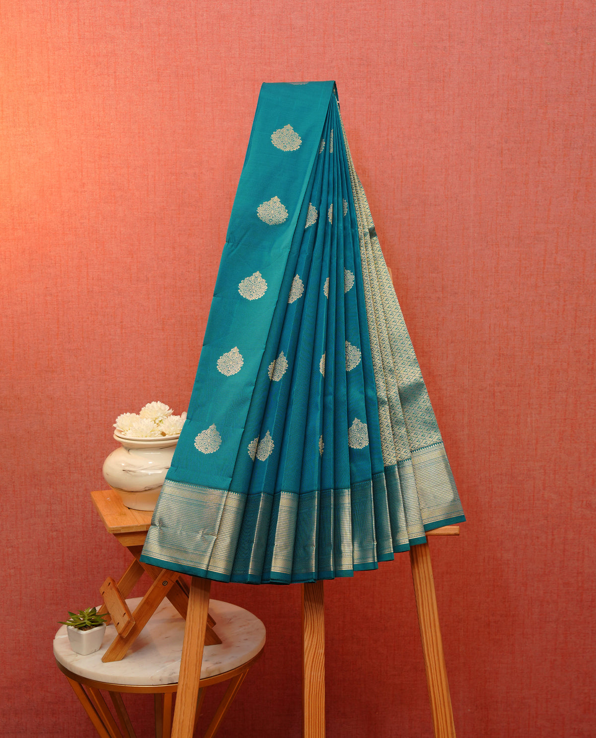 Peacock blue colour soft silk saree featuring gold zari floral motifs on body, contrast by self colour gold zari traditional border, grand pallu comes with matching blouse piece.