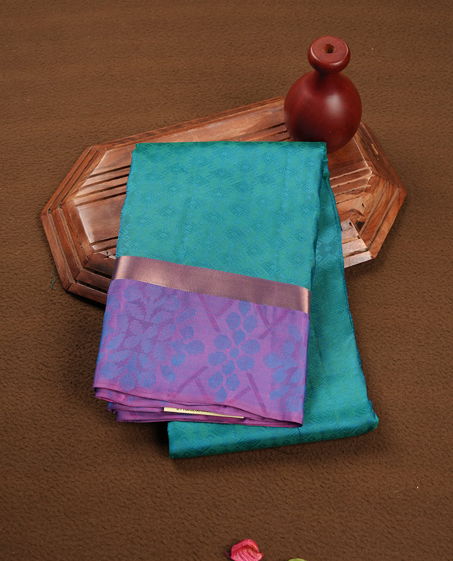 Peacock colour soft silk saree featuring gold zari motifs on the body, complemented by a contrast Indigo traditional zari kodi border and pallu, paired with a matching blouse piece.