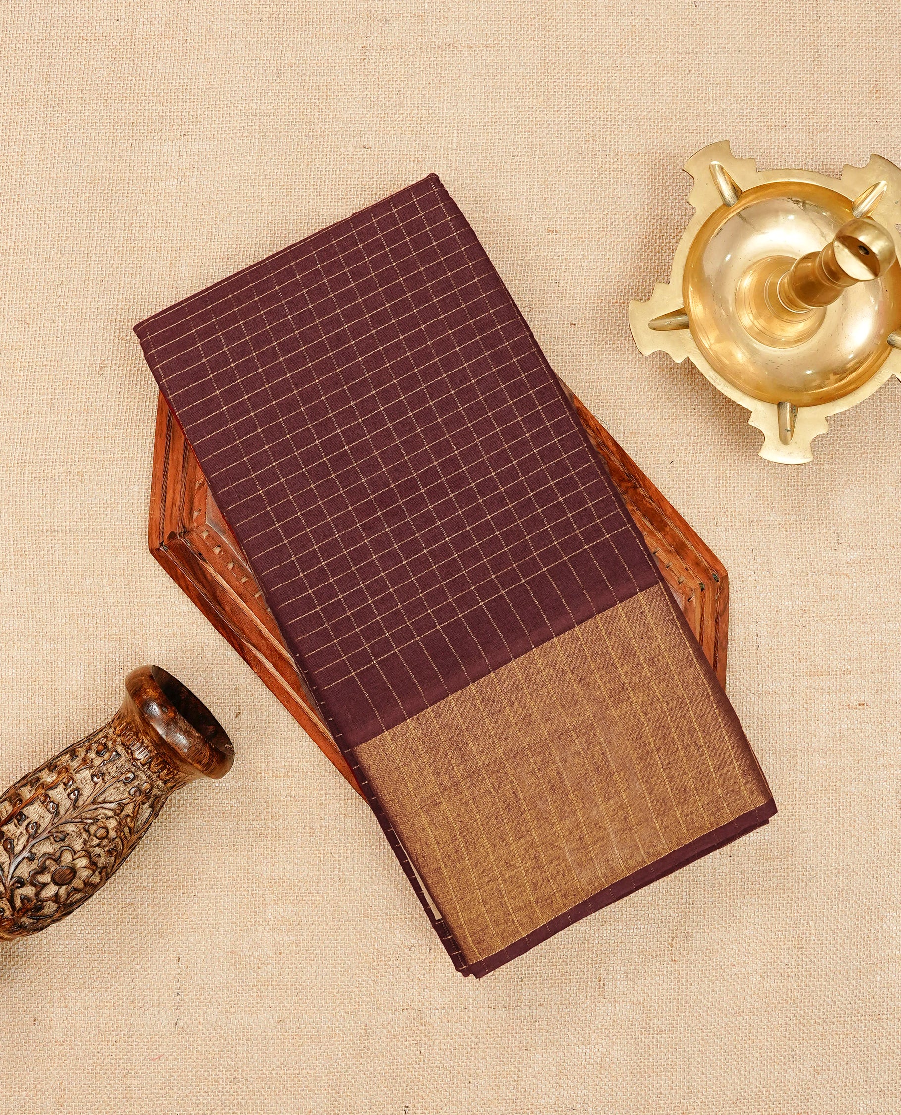 Brown Sungudi cotton saree featuring elegant gold zari checks across the body, complemented by a contrast gold zari border. Comes with a matching blouse piece.