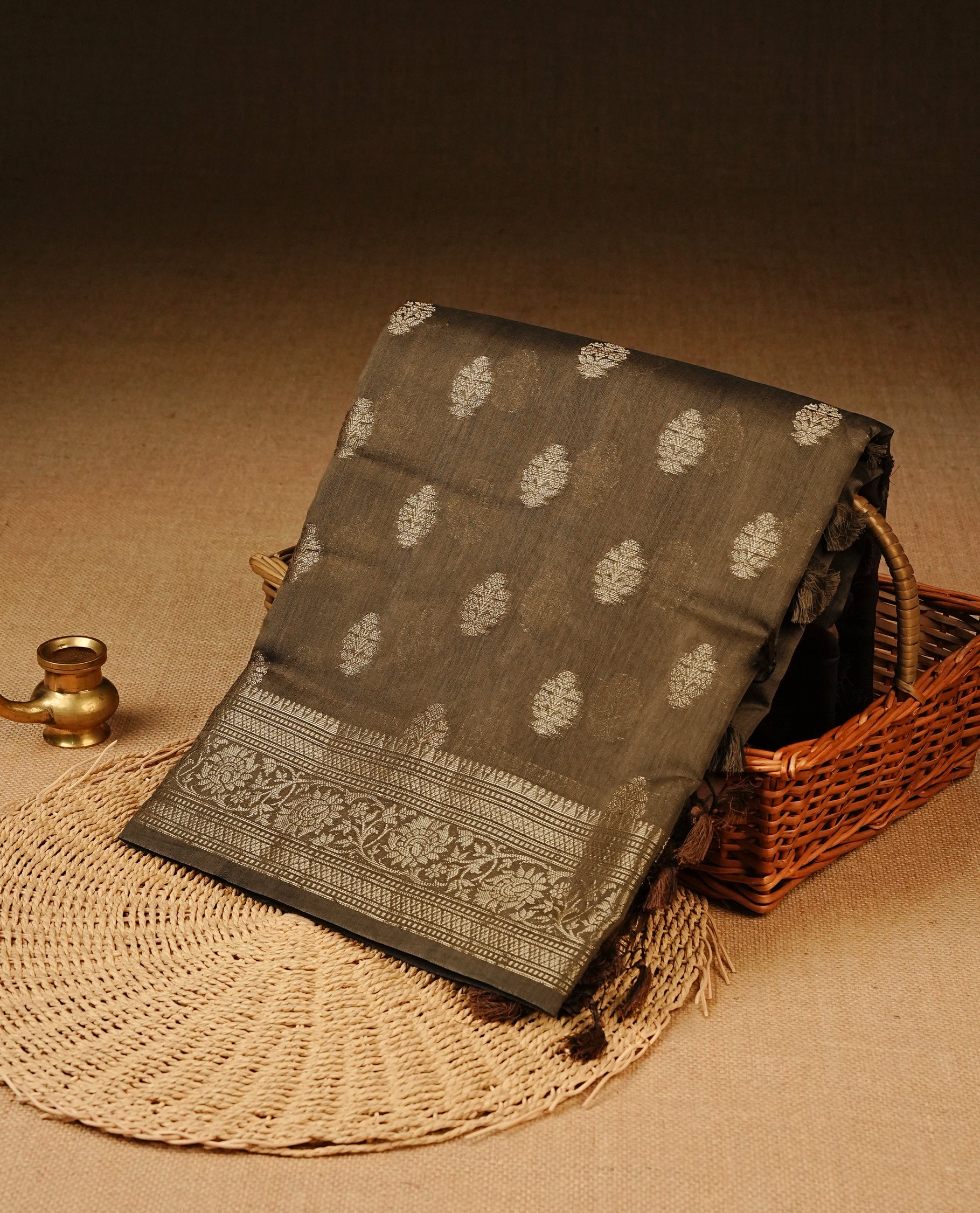 Khaki Brown Colour Tussar Silk saree with antique zari butta motifs On Body, a self-toned floral zari border, a rich zari pallu, and a matching blouse piece.