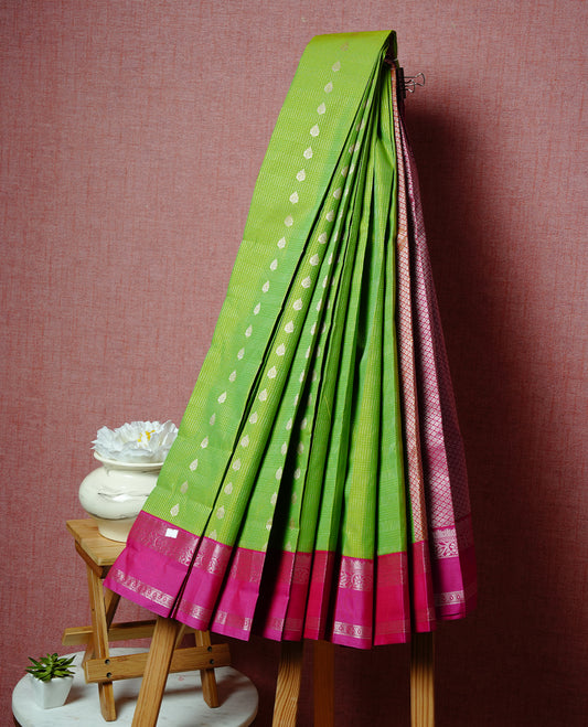 Lemon coloured soft silk saree featuring gold zari stripes and motifs across the body, enhanced with a contrast rani pink border and pallu, paired with a matching contrast blouse piece
