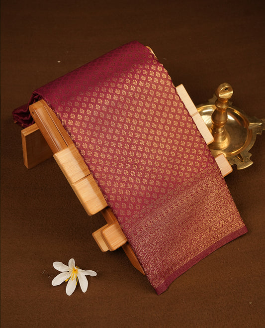 Maroon colour semi soft silk saree featuring gold zari motifs on across body, self colour border with traditional gold zari pattern, pallu and paired with matching blouse.