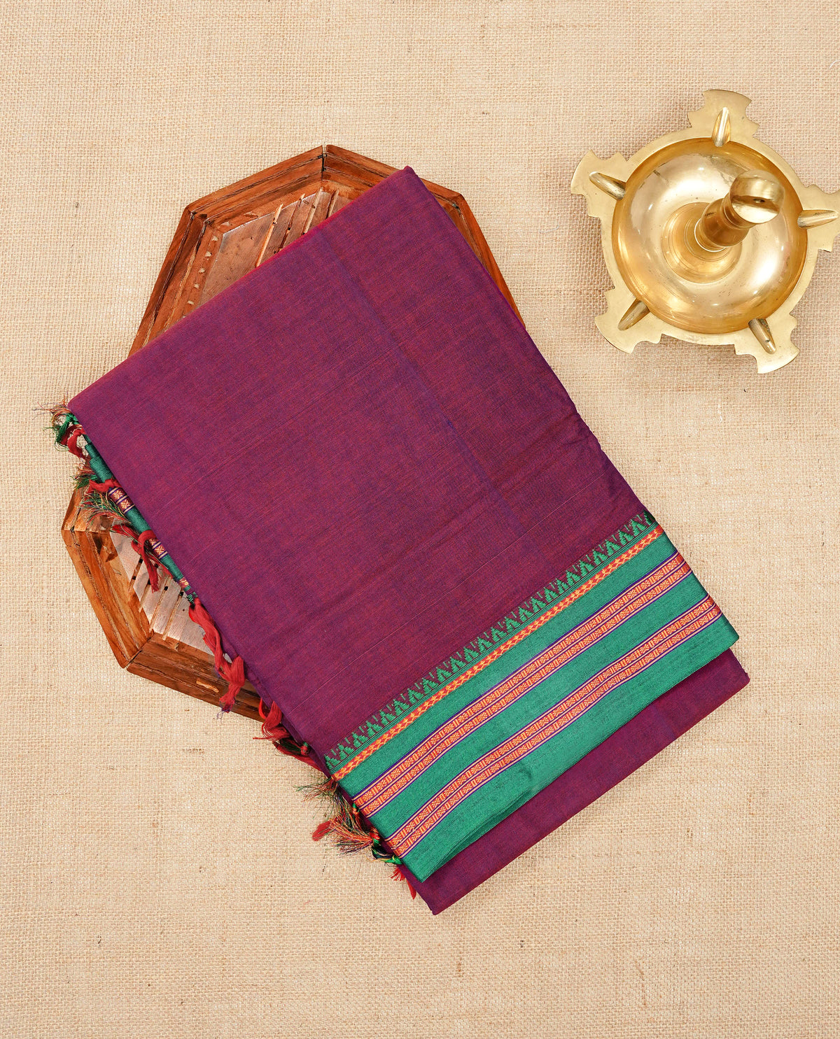Dark magenta colour Narayanapattu cotton saree with a plain body, complemented by a green colour with gold zari border & contrast pallu, paired with a matching blouse piece.
