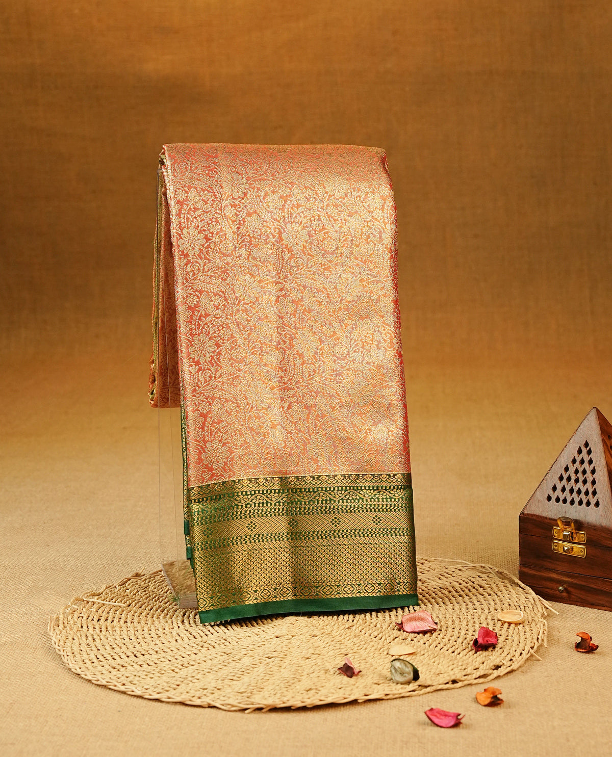 Red colour Semi Tissue Silk Saree featuring gold zari floral kodi Works on the body, complemented by an intricately woven gold zari pallu, a rich Green border with gold zari work and paired with a matching plain blouse piece.