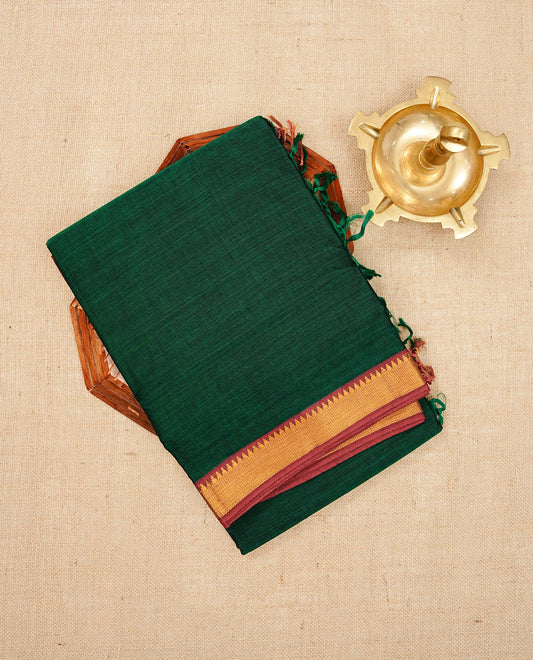 Bottle Green colour Narayanapattu cotton saree with a plain body, complemented by a red colour with Gold Zari border & contrast pallu, paired with a matching blouse piece.