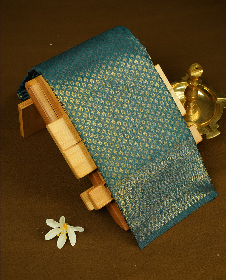 Teal colour semi soft silk saree featuring gold zari motifs on across body, self colour border with traditional gold zari pattern, pallu and paired with matching blouse.