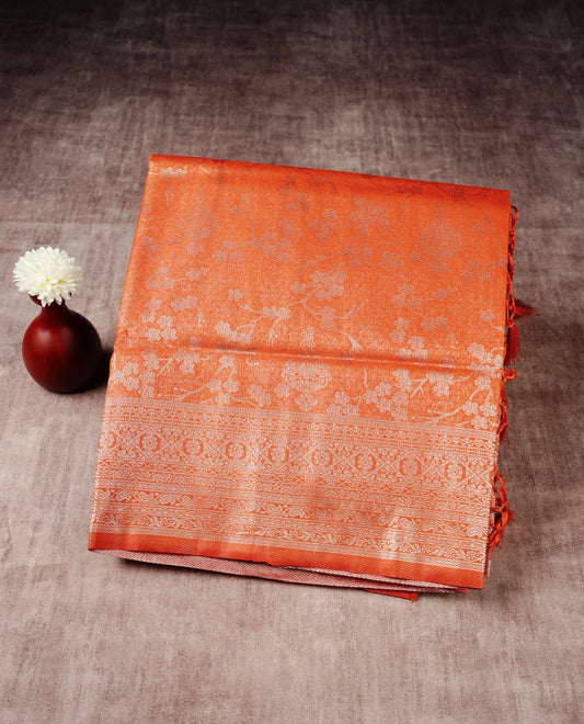 Orange colour softie silk saree featuring silver zari, rich pallu floral brocade body, with contrasting self colour border.paired with matching blouse piece.