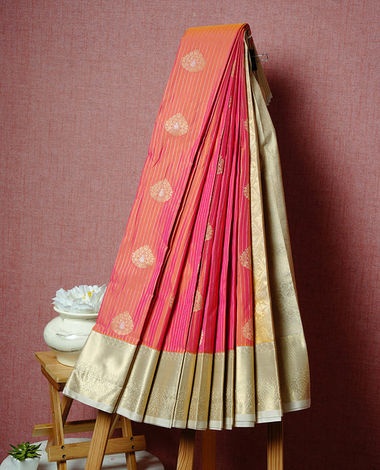 Orange coloured soft silk saree featuring gold zari stripes and motifs across the body, enhanced with a contrast Cream border and pallu, paired with a matching contrast blouse piece.