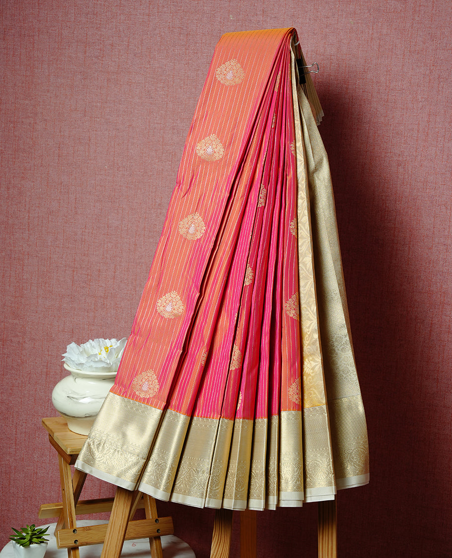 Orange coloured soft silk saree featuring gold zari stripes and motifs across the body, enhanced with a contrast Cream border and pallu, paired with a matching contrast blouse piece.