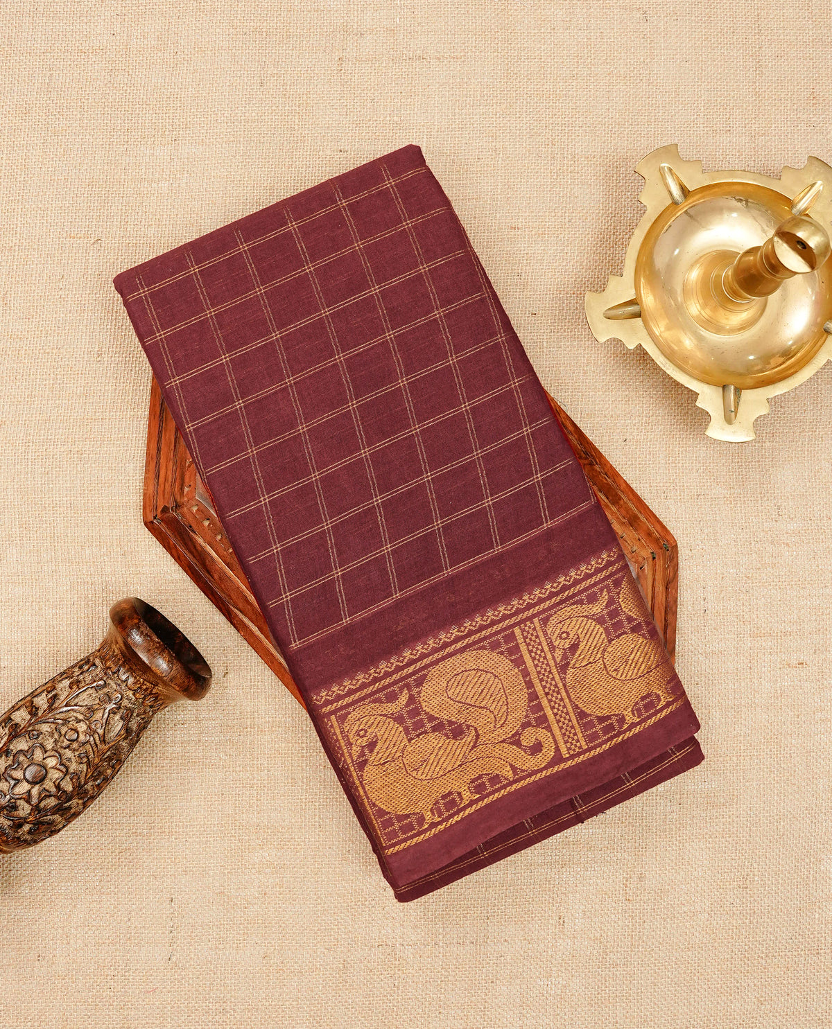Maroon Sungudi cotton saree featuring elegant gold zari checks across the body, complemented by a rich gold zari peacock border. Paired with a matching blouse piece