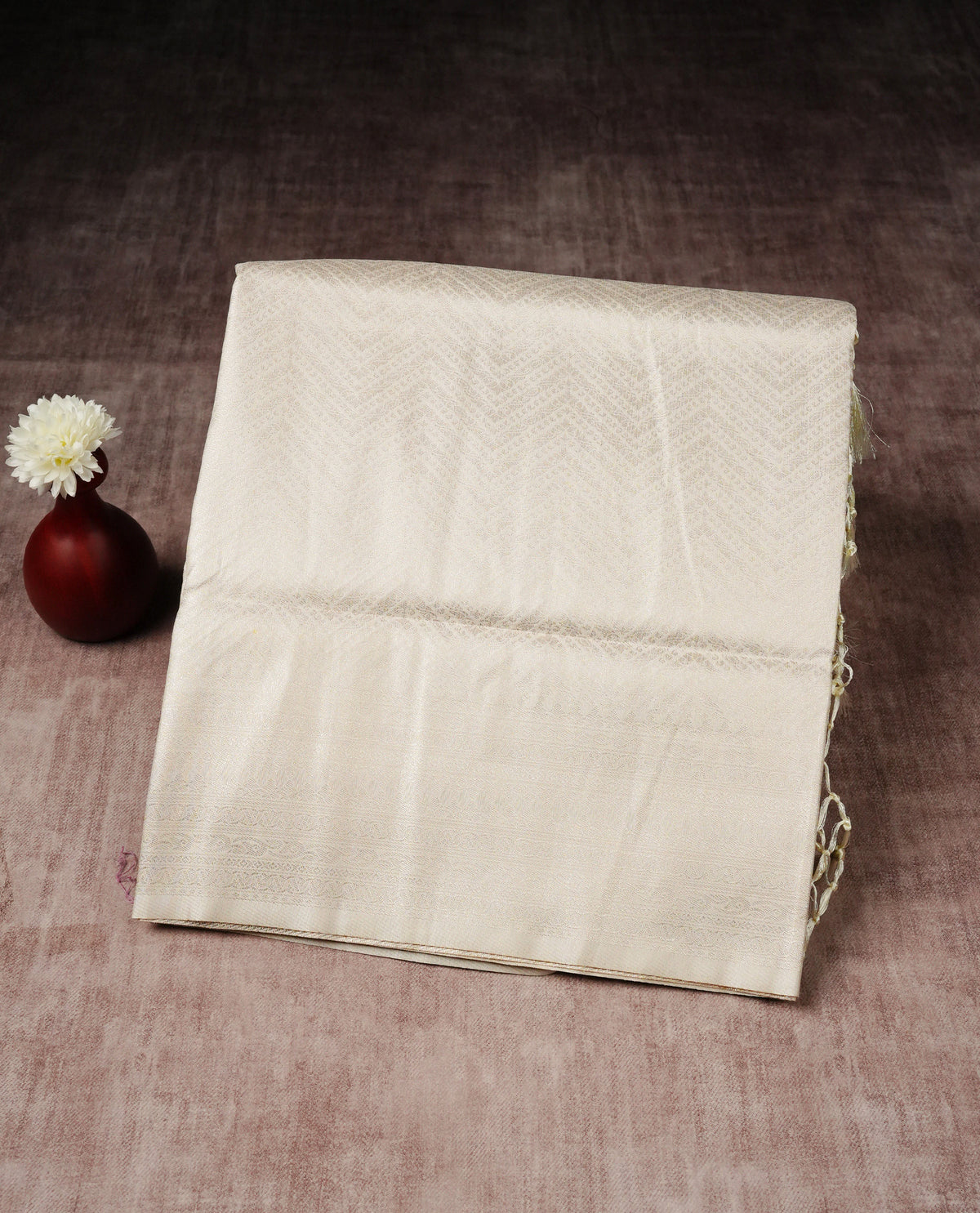 Off white colour softie silk saree featuring silver zari, rich pallu chevron pattern brocade body, with contrasting self colour border.paired with matching blouse piece.