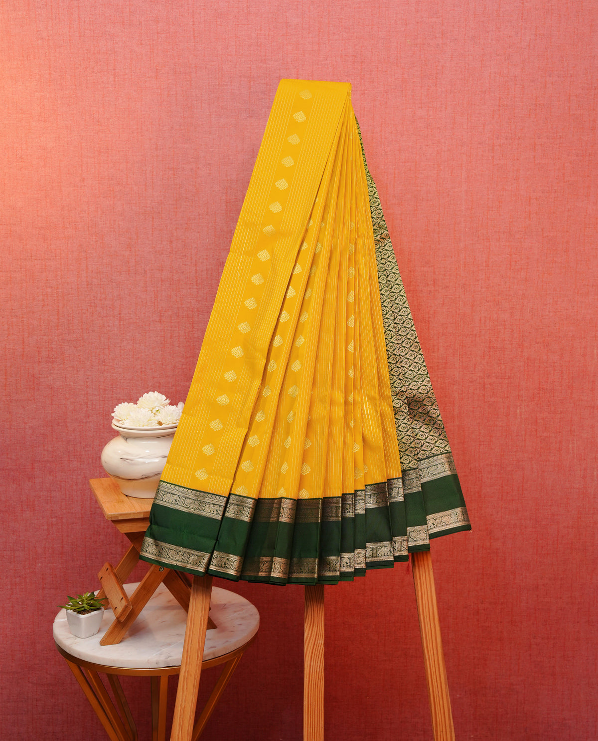 Mustard yellow colour soft silk saree featuring floral gold zari stripes with motifs on body, contrast dark green colour detailed elephant & peacock motifs on border, grand pallu comes with matching blouse piece.